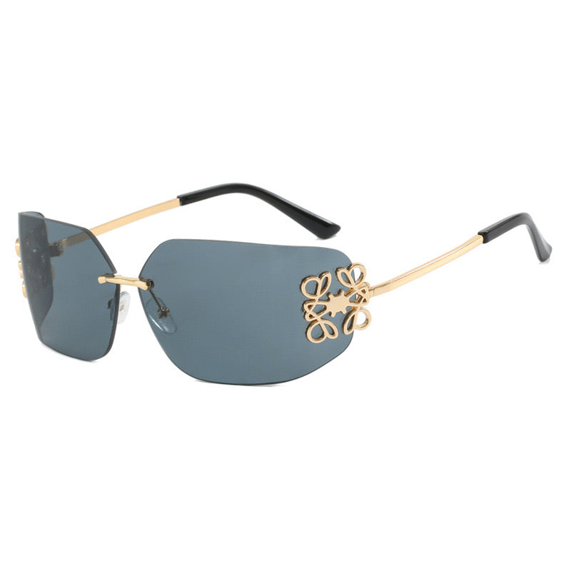 Gafas de sol gris con detalles dorados.